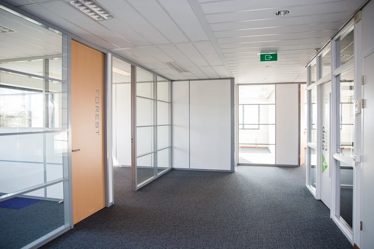 Lichte en moderne kantoorruimte aan de Laan van 's-Gravenmade met glazen wanden en een deur met het opschrift "FOREST".